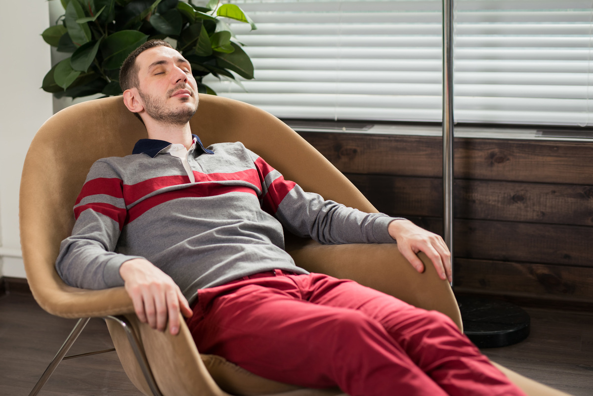 Adult patient resting comfortably in a chair during a supervised Spravato treatment session