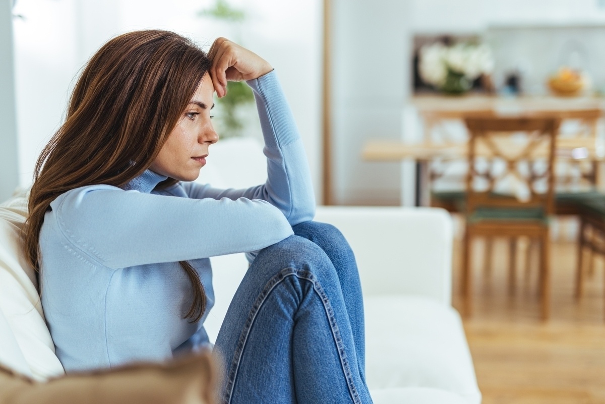 Adult woman sitting quietly overwhelmed by emotion representing the experience of rejection sensitive dysphoria in ADHD