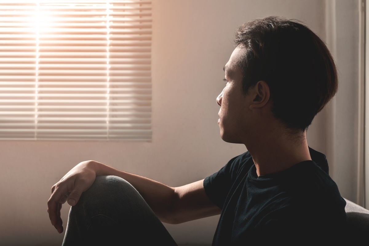Adult sitting quietly and reflectively representing the connection between unresolved trauma and depression