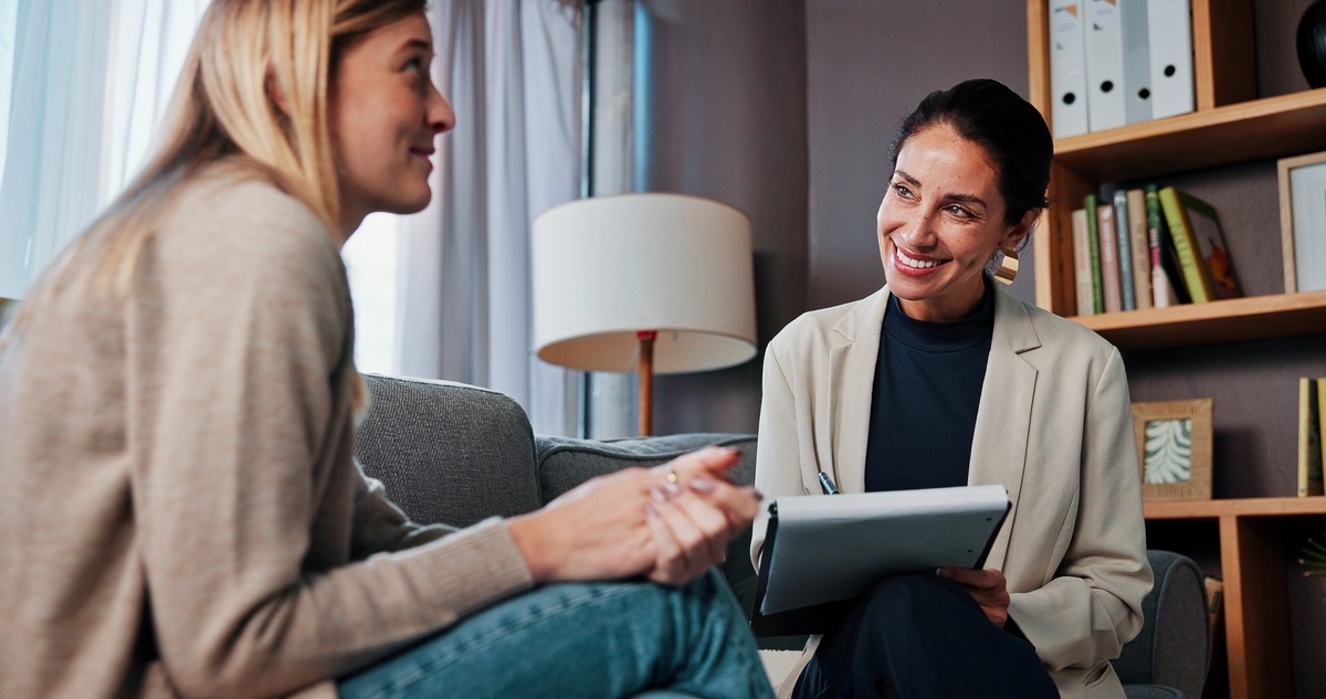 Smiling psychiatric provider with tablet consulting adult patient about Spravato treatment in Apache Junction AZ